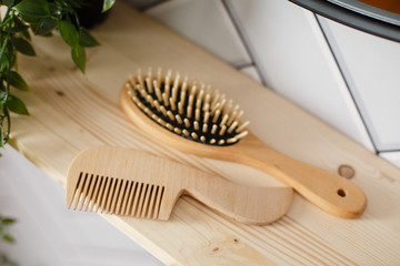 Spa and bath cosmetics, basket with towel rolls in rustic interior. Natural materials in bathroom. Wooden hair brush. Bamboo comb on the dressing table. Eco-friendly hair care products. Natural beauty - obrazy, fototapety, plakaty