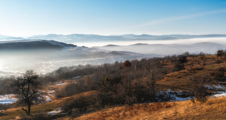 Early spring mountain landscape panorama with fog and low clouds 