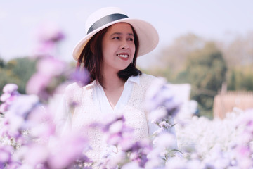 Asian middle-aged women wearing a white sombrero enjoying Purple margaret field,  Relaxing outdoor,...