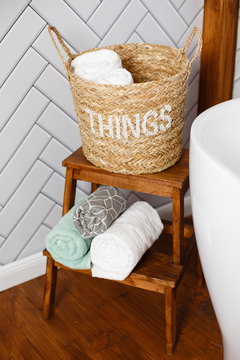 Bathroom interior details. Spa and bath cosmetics, basket with towel rolls in rustic interior. Natural materials in bathroom. Freshness and body care. Modern bathroom. Dirty laundry basket