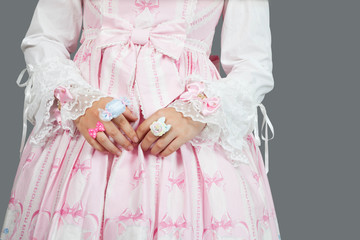 Mid section of young woman dressed as a doll over gray background