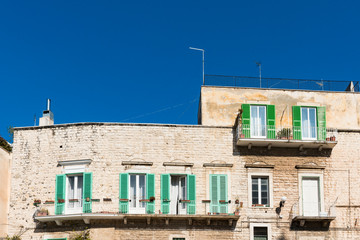 Fototapeta na wymiar white apartments with balcony and green wooden shutters. Molfetta, Italy