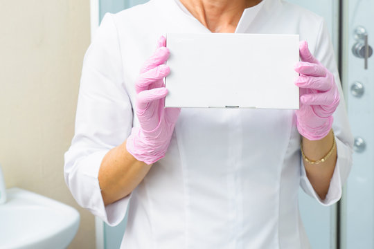 Closeup photo of cosmetologist's hands holding white box with fillers. Health care, Medical and Pharmacy Concept. Mock up for your project
