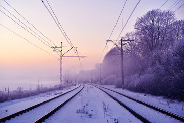 Winter railway landscape in the provincial countryside of Finland on a snowy, foggy morning