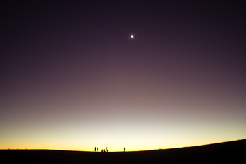 sunset in desert with silhouette people in background