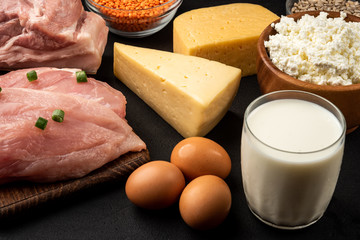 High protein food - meat, chicken, dairy products, seeds, legumes and eggs on black background....
