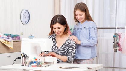 Novice tailor learning from her master art of making templates for sewing