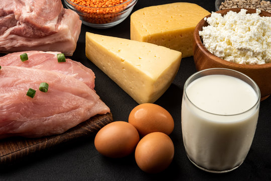 High protein food - meat, chicken, dairy products, seeds, legumes and eggs on black background. Healthy products.