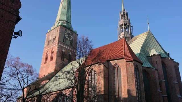 Church of Saint Jacobi, historic landmark in brick gothic architecture with green copper roof and ridge turret  in the old town of Luebeck, Germany,  blue sky