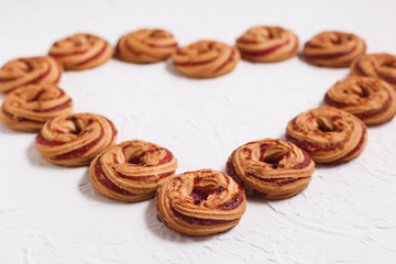 Shortbread cookies with berry jam close-up on a white background arranged in the form of a heart