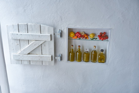 small shelf on the wall with bottles bottle olive oil and vegetables tomatos lemon paprika and garlic,old house apartment modern living barn shutter country style mood