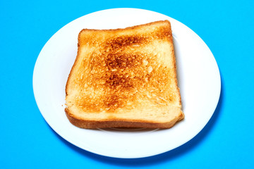 Toasted toast on a plate on a blue background.