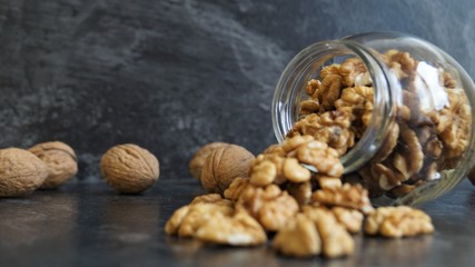 peeled walnut kernels in a glass jar for storing food on a light background