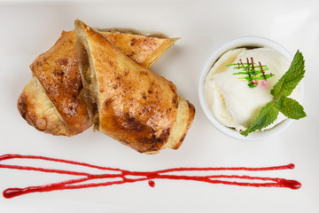 Apple strudel with vanilla ice cream decorated with caramel and berries sauce