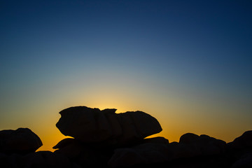 Strange rock formations silhouetted against sunset along the Côte de granit rose / Pink Granite...