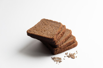 Grain brown bread with  coriander and caraway seeds on white background