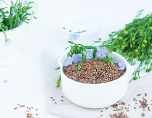 Flax Seeds and Blue Flax Flowers Bunch on White Table