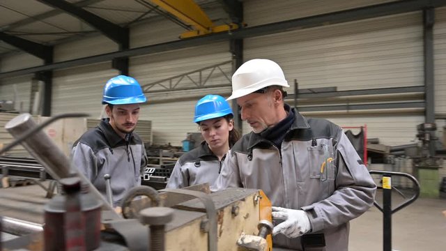 Steelwork instructor with young apprentice in workshop