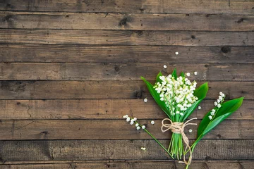 Zelfklevend Fotobehang White Spring Flowers. Bouquet of Lily of the valley on a Dark Brown Wooden Background. Greeting for Womens, Mothers Day, Birthday party. Copy space © AllNikArt
