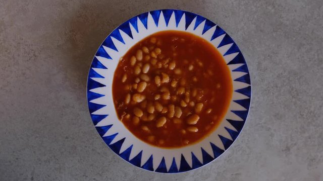 Turkish Kuru Fasulye also known as Baked Beans. Healthy food. Slow Motion camera rotation, top view.