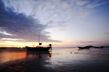 Old fishing boat at sunset and blurred clouds.