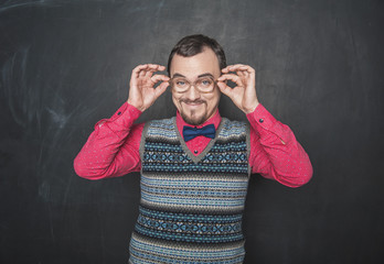 Funny retro style teacher in eyeglasses looking at you on blackboard