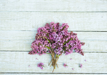 Bouquet of purple lilac flowers on a shabby wooden background. Vintage floral background with spring flowers. Copy space
