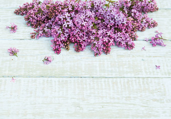 Bouquet of purple lilac flowers on a shabby wooden background. Vintage floral background with spring flowers. Copy space