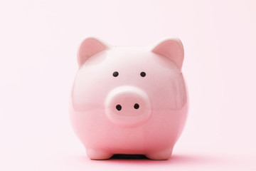 Piggy bank on a pink background, front view