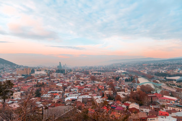 Fototapeta premium Tbilisi, Georgia, 15 December 2019 - travel card of cableway cabin on the background of cityview at the sunset