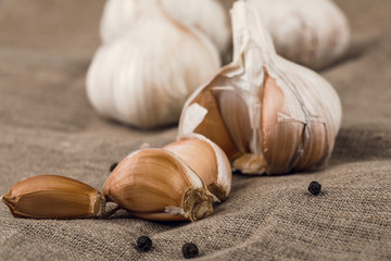 garlic cloves in wooden plate on burlap background