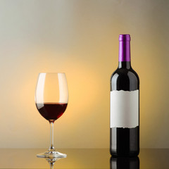 a bottle of red wine with space for your text and a glass of wine