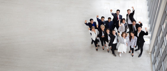 Top view of group of multiethnic business people celebrating and .happy success positive teamwork with hands up. Victory successful, celebrate achievement and acquisitions concept. Aerial view.