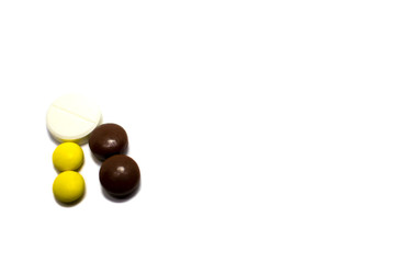 Multi-colored pills on a white background, place for text.