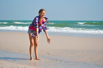 Fototapeta na wymiar Vacation at sea with children. Baby girl running at sea beach.