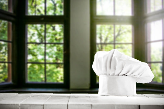 White cook hat on wooden board and free space for your decoration. 