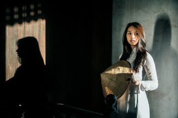 Alone woman wearing Ao Dai is Vietnam traditional dress in the old house France style
