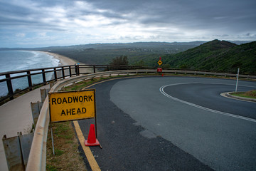 Roadwork Ahead Sign at Byron Bay Lighthouse overlooking Tallow Beach, Queensland Australia. 