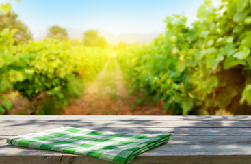 Wooden table in front of vineyard