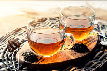 two cups of black tea on a wicker table early in the morning, closeup. Tea morning at dawn.