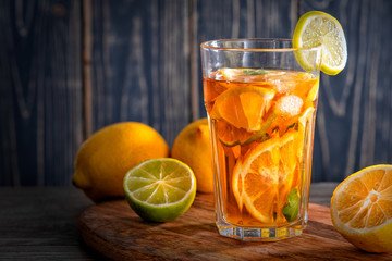 Lemonade with ice and mint on old wooden boards. Ice tea with lemon and lime on a wooden table, close up.