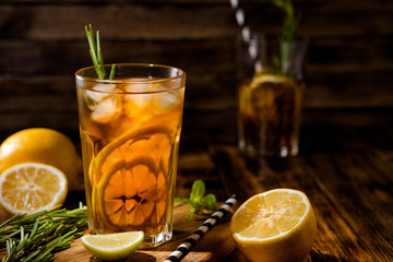 Lemonade with ice and mint on old wooden boards. Ice tea with lemon and lime on a wooden table, close up.