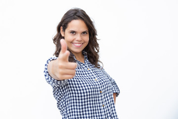 Fototapeta premium Content young woman showing finger gun symbol. Beautiful cheerful young woman showing hand gun gesture and smiling at camera. Gesturing concept