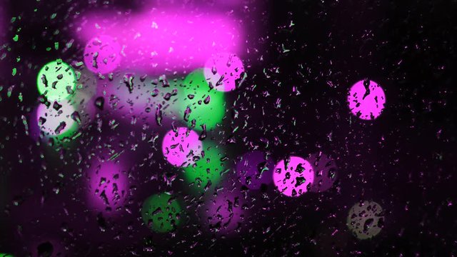 Abstract background with blurred flashlights outside the window. Concept. Colored lanterns behind the glass