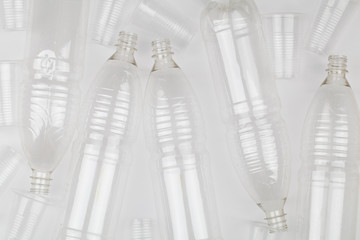 empty plastic bottles and glasses on white background.