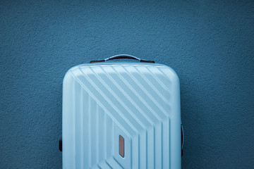 Blue travel bag on blue background.