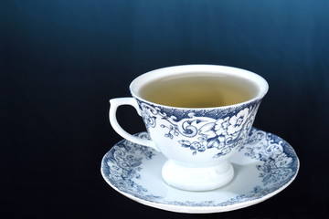 wooden table with cup of tea with rosemary branches isolated on blue gradient background with space for text.