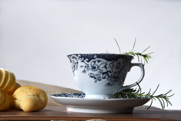 Brazilian snack on the table with cup of tea, cheese biscuit, vase with flowers on the gradient background with space for text