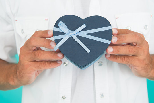 Male manicure. Hands hold gift box close up. Beauty industry. Present with love. Happy valentines day. Romantic greeting. Hands can be big first impression. Clean nails and soften skin. Hands care