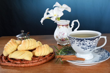 table with cup of tea with pieces of cinnamon isolated on red background with space for text